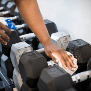 Wiping down weights in gym Wiping down weights in gym